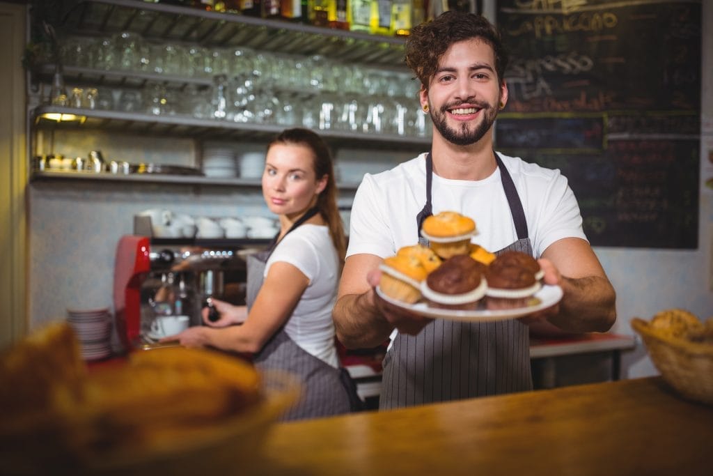 portrait waiter holding plate cup cake counter Kantin İşletme Sertifikası Nasıl Alınır?