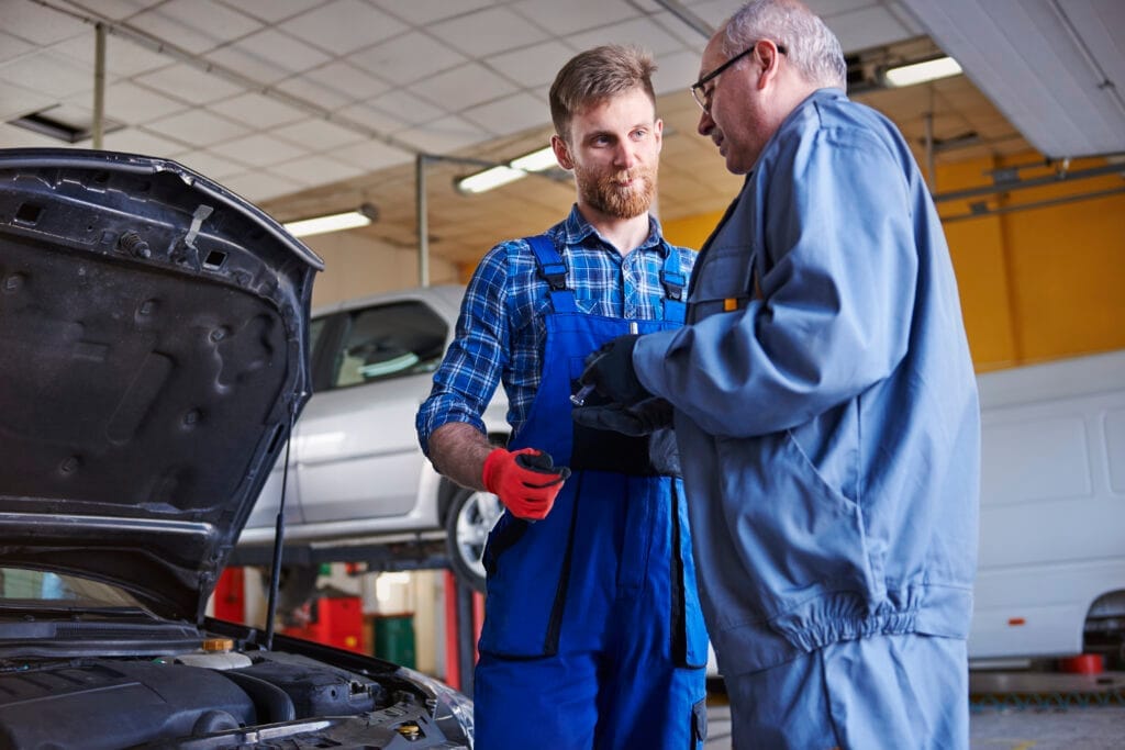 mechanics repairing car workshop Otomotiv Montaj Belgesi Nasıl Alınır?