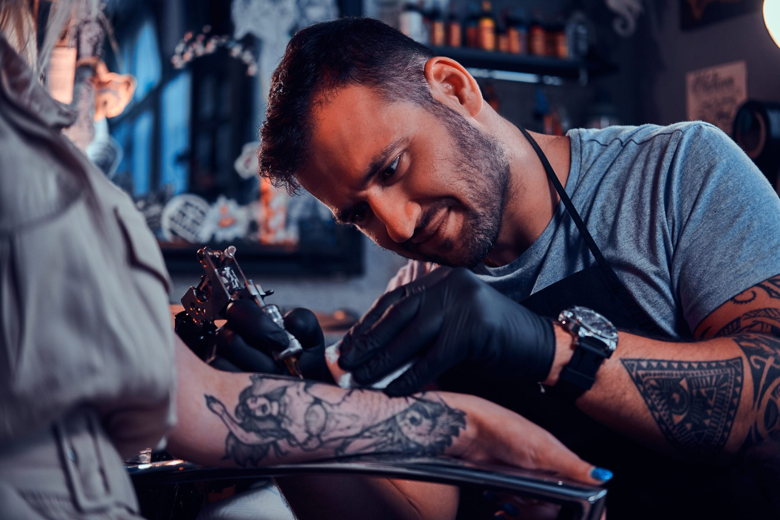 dilligent focused tattoo artist is creating new tattoo young woman s hand tatoo studio scaled Dövme Ustalık Belgesi Nasıl Alınır?