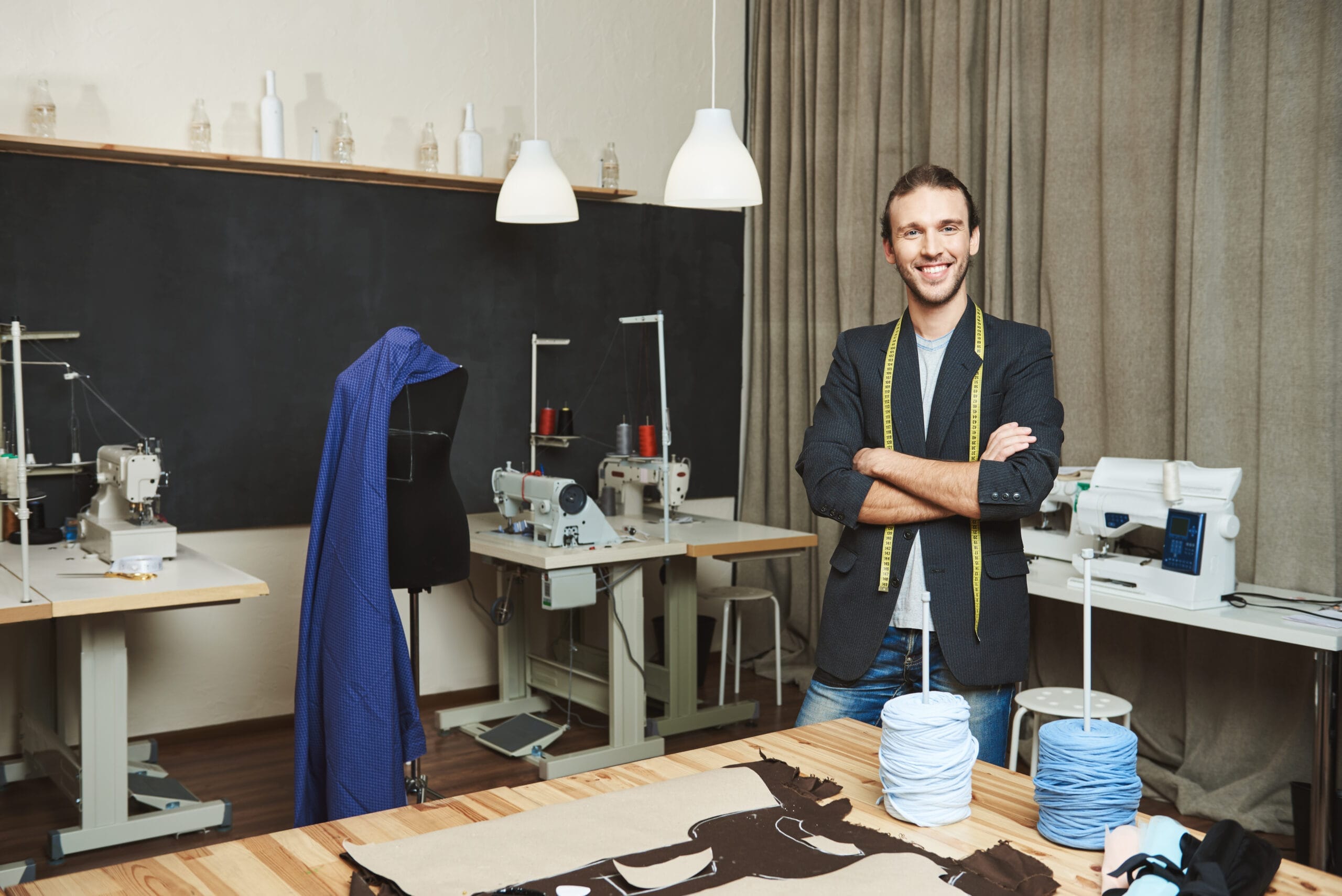 portrait cheerful good looking male clothes designer with dark hair fashionable outfit standing workshop posing article about his brand artist standing his comfy studio scaled Terzi Ustalık Belgesi Nasıl Alınır