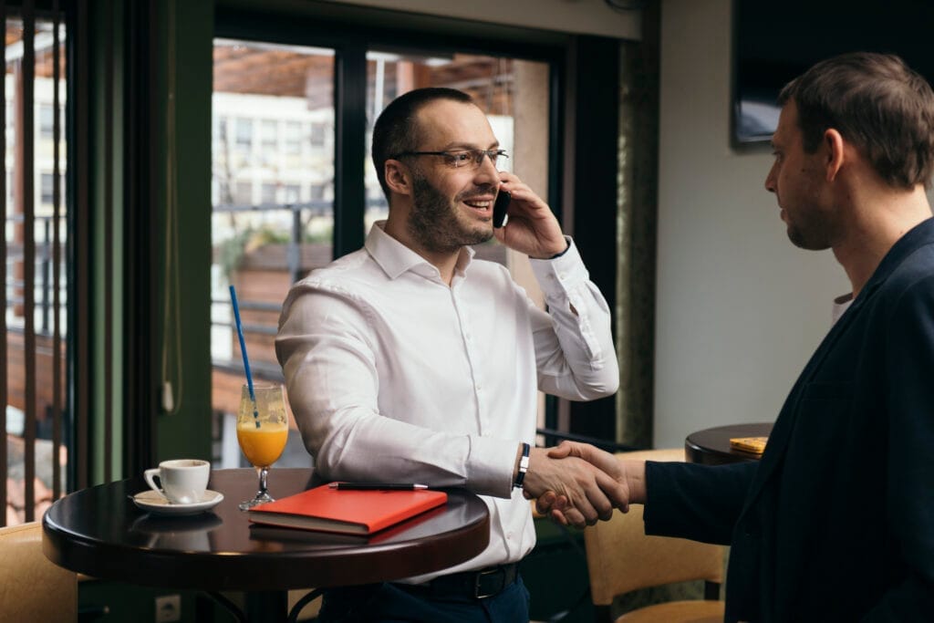 businessman with smartphone greeting man Halkla İlişkiler Sertifikası ile Ne İş Yapılır