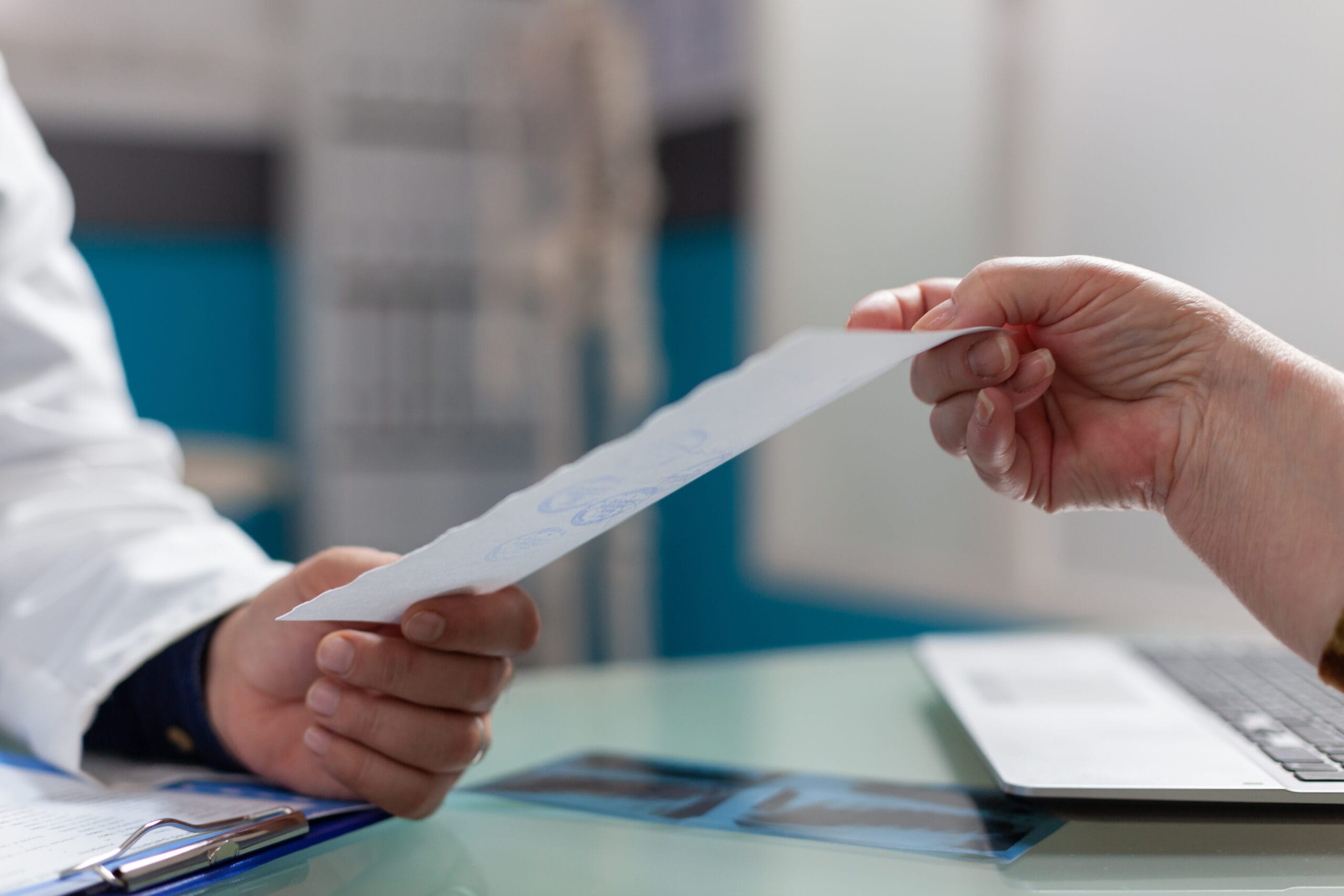 physician giving prescription document patient cabinet after medical consultation medic holding checkup report give treatment retired person health care office close up 1 scaled Hastane Sekreteri Ne İş Yapar