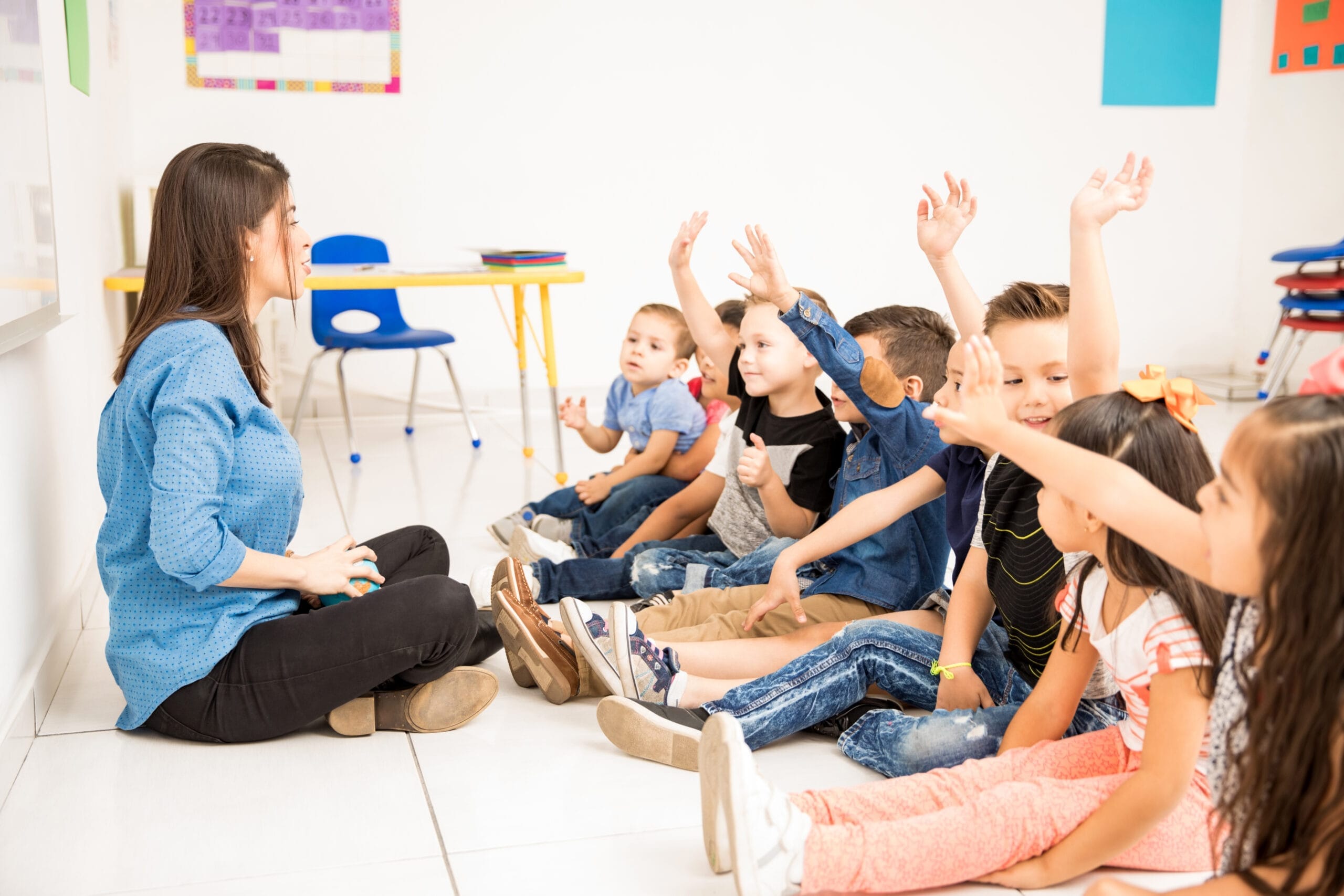 profile view group preschool students raising their hands trying participate school scaled Anaokulu Kreş Öğretmenliği Kursu