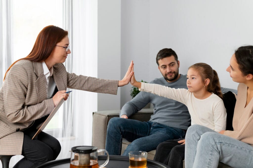 close up girl therapist high five Aile Dizimi Eğitimi Fiyatları