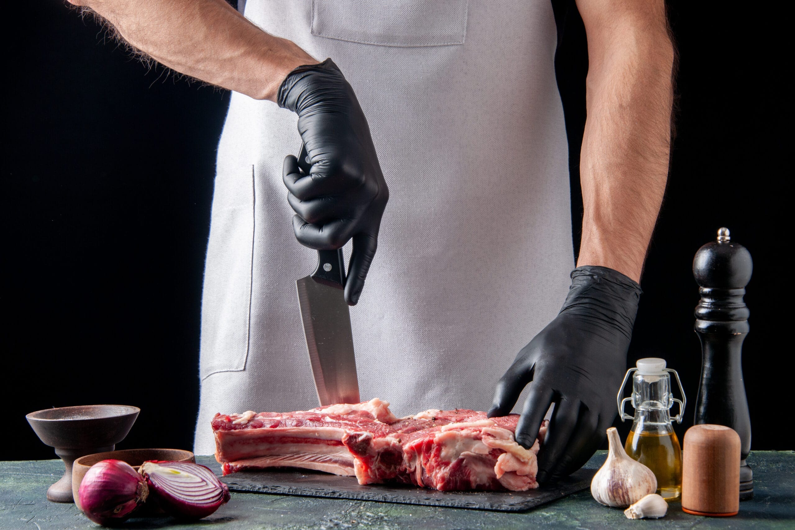 front view male butcher cutting meat dark surface 1 scaled Kasaplık Ustalık Belgesi Nasıl Alınır?