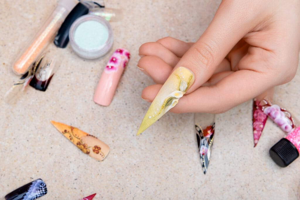 girl trying artificial nails tips with flower nail design Protez Tırnak Sertifikası Nasıl Alınır