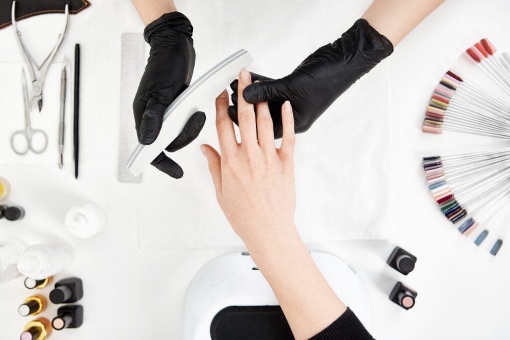nail tech filing nails with nail file professional manicure tools Protez Tırnak Sertifikası Nasıl Alınır