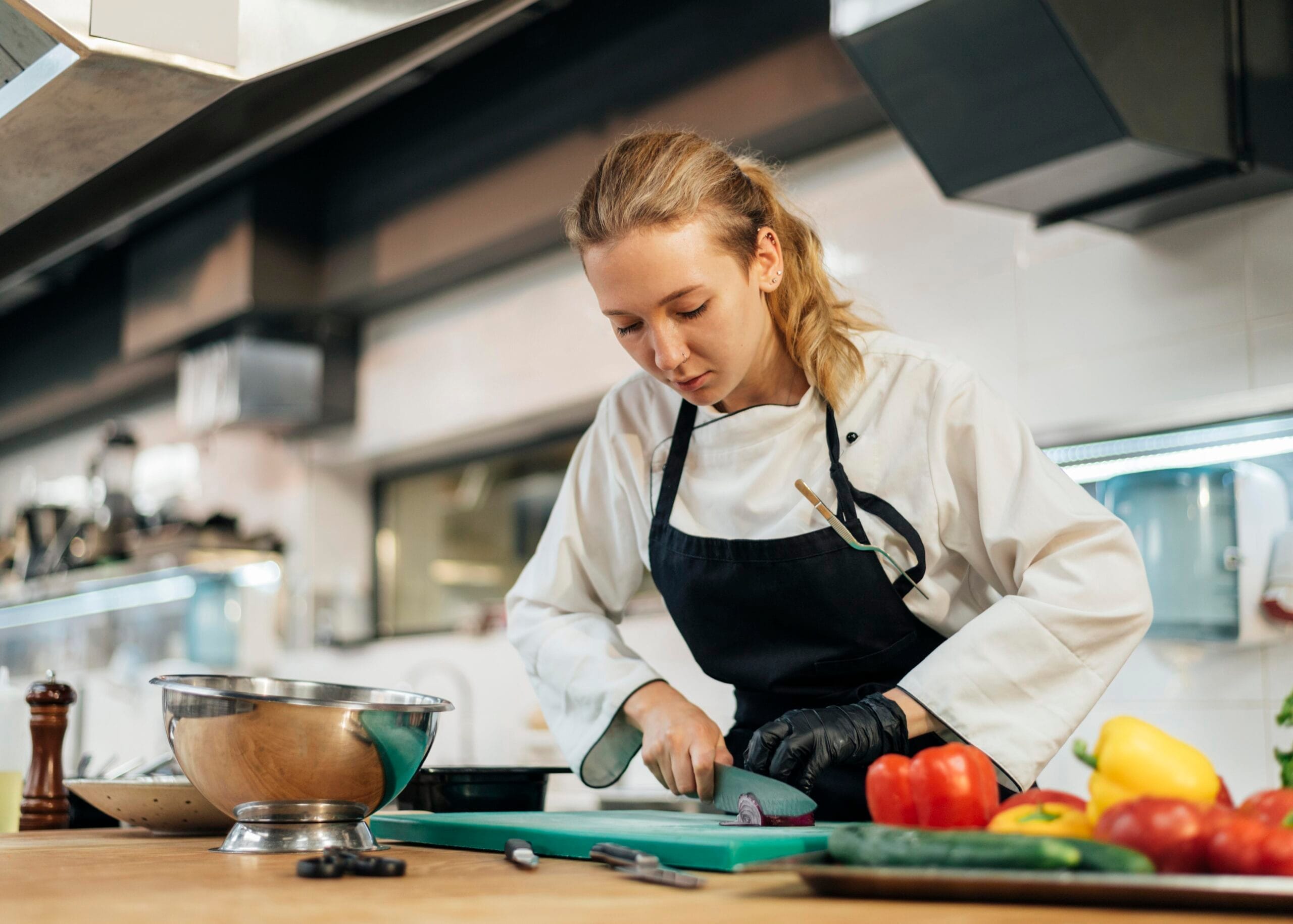 female chef chopping vegetables kitchen scaled Aşçılık Belgesi Nasıl Alınır?