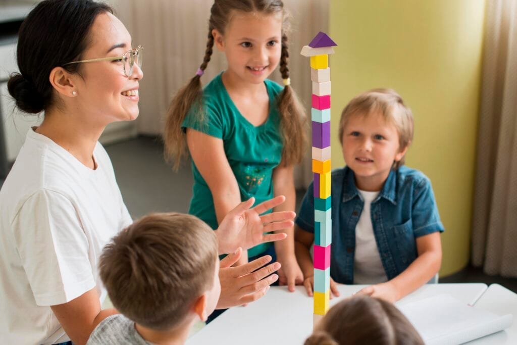 woman teaching kids how play with colorful tower Özel Eğitim Belgesi Nereden Alınır?